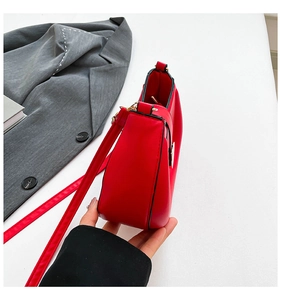 Detailed side view of a red saddle bag with smooth leather finish and fine stitching