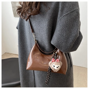 Detail of vintage oil wax leather hobo bag with ShellieMay plush toy charm and gold buckle