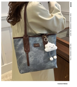 Detail of grey marble pattern tote bag with brown leather handles and cloud charm
