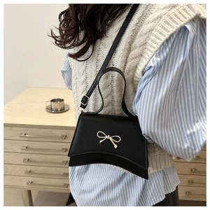 Détail du sac à bandoulière noir en cuir PU avec nœud métallique doré élégant