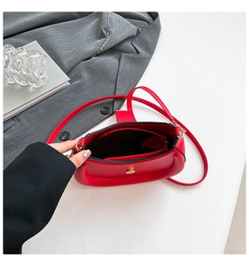 Detailed interior of red saddle bag showing smooth PU leather and magnetic buckle closure
