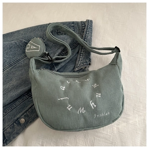 Detail of green corduroy crescent bag with letter embroidery and round coin purse