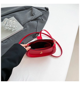 Detail of red PU leather saddle bag showing interior compartment and zipper pocket
