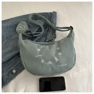 Detail of mint green corduroy crescent bag with embroidery and heart-shaped coin purse
