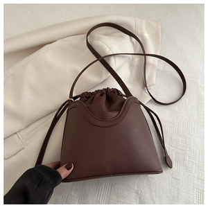Detail of vintage brown drawstring bucket bag with premium PU texture and inner pouch
