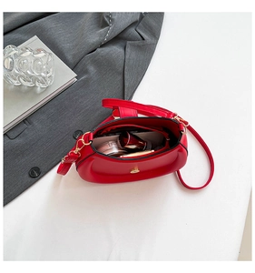 Internal view of red leather saddle bag showing storage space for makeup and zipper pocket