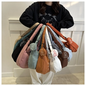 Detailed view of colorful corduroy crossbody bags with embroidered letter A coin pouches