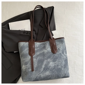 Chic textured grey tote bag styled with a dark grey blazer and a minimalist book