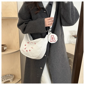 Detail of white corduroy half-moon bag with red letter embroidery and round coin purse