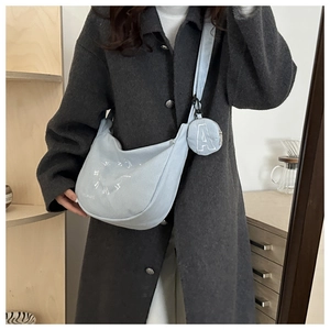 Detailed texture of light blue corduroy crescent bag with embroidered round coin pouch