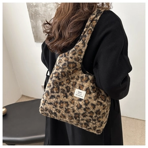 Detailansicht der flauschigen Leopardenstruktur und des weißen Labels der Schultertasche
