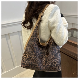 Détail du grand sac cabas à motif léopard avec bandoulière ajustable sur un modèle