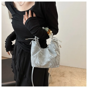 Detail of silver marble pattern bucket bag with colorful beaded handle and drawstring closure
