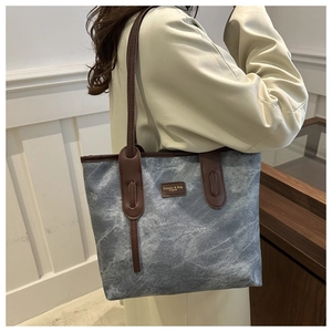 Close-up of retro canvas tote bag with leather straps and classic logo label detailing