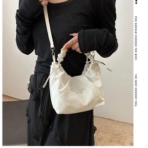 Detail of white marble pattern bucket bag with resin beaded handle and drawstring closure