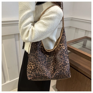 Sac hobo imprimé léopard avec bordure en cuir marron porté comme un sac à bandoulière