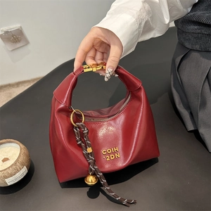 Chic burgundy crescent underarm bag with gold metal buckle and woven bell charm