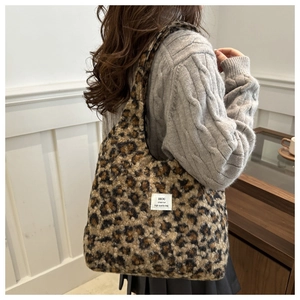 Makro-Detail der Plüsch-Leopard-Fellstruktur und des Markenlabels der Hobo-Tasche