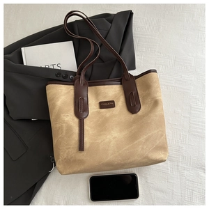 Flat lay of vintage canvas tote bag with brown leather trim and logo label detail