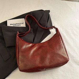 Deep red vintage hobo shoulder bag in faux leather on professional lifestyle background
