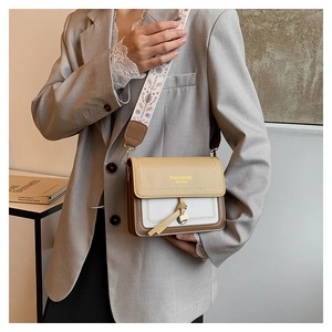 Detail of trendy color-block crossbody bag with vintage embroidered wide strap on model