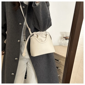 Chic beige bucket bag with drawstring closure and structured base for commute