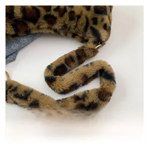 Gros plan sur la bandoulière en peluche léopard avec connecteur en métal doré