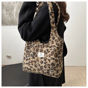 Detailaufnahme der Plüsch-Tragetasche mit Leopardenmuster und weißem Webetikett