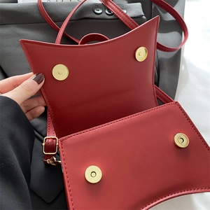 Fashionable red geometric handbag with bow detail and adjustable shoulder strap