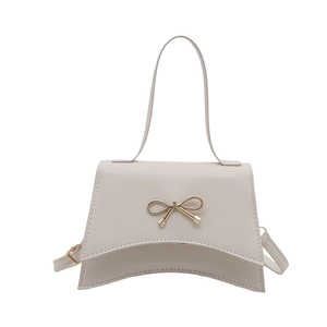 White trapezoidal handbag with golden bow lock and adjustable shoulder strap