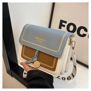 Detail of tricolor leather crossbody bag with wide printed strap and golden hardware