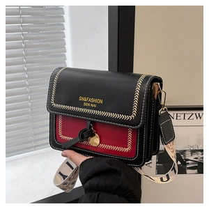 Detail of crossbody bag featuring contrast embroidery and wide branded strap