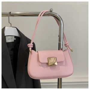 Detail of light pink shoulder bag with large gold square buckle and matte leather texture