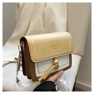 Detailed close-up of tricolor crossbody bag with leather flap and wide patterned strap