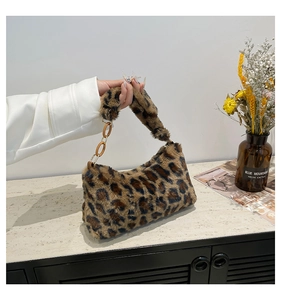 Détail d'un sac à main en peluche léopard avec chaîne marron clair et fermeture éclair