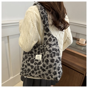 Detailansicht einer Plüsch-Schultertasche mit Leopardenmuster, getragen im Herbstlook