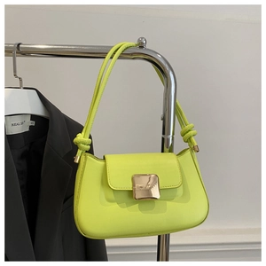 Detail of neon green underarm bag featuring golden buckle and knotted shoulder strap