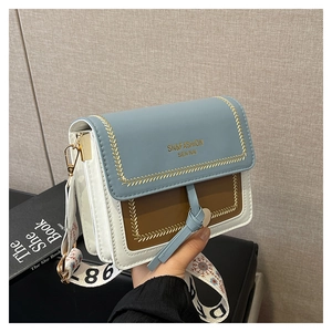 Detail of the tricolor crossbody bag with embroidery, fringe, and wide shoulder strap