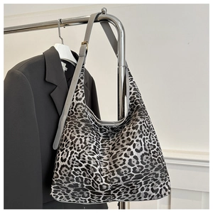 Détail du cabas imprimé léopard avec bandoulière en cuir gris et boucle dorée