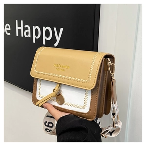 Close-up of color-block crossbody bag featuring yellow flap and printed wide strap