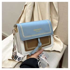 Detail showing contrast color PU leather bag with embroidery stitching and chic wide strap
