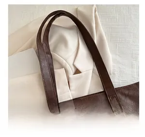 Close-up of a dark brown textured leather tote bag with meticulous stitching and soft finish