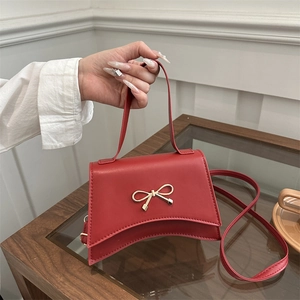Sac à main trapèze rouge élégant avec nœud doré et bandoulière pour femme moderne