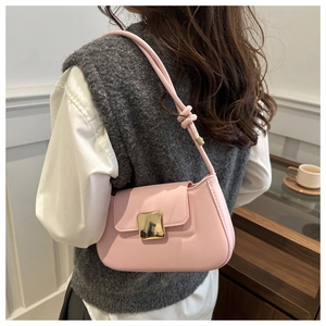 Detail of pink leather shoulder bag with gold square buckle and stylish knotted strap