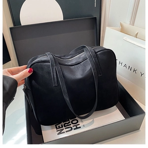 Black matte suede shoulder bag presented in a gift box with silver zipper detail