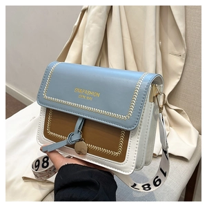Detail of color-block leather crossbody bag with wide strap and golden logo branding