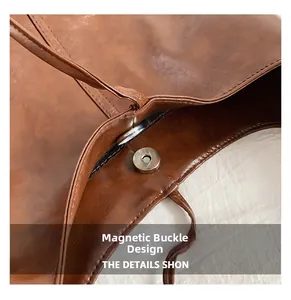Close-up of the secure magnetic closure on a brown faux leather tote bag