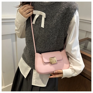 Detail of pink leather crossbody bag with a polished gold square metal buckle closure