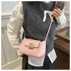 Detailed view of a pink leather shoulder bag with a square golden buckle and slim strap