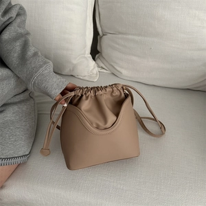 Retro light brown drawstring bucket bag made of matte faux leather with shoulder strap